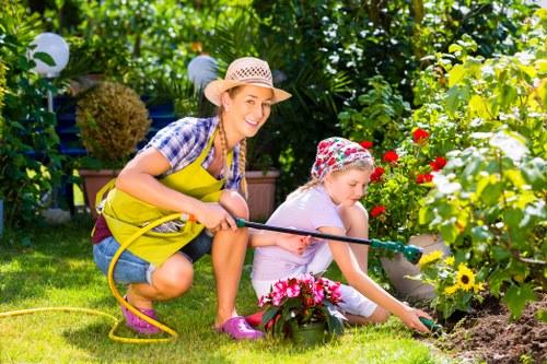 Hedge trimming team at work using hand and powered tools in local neighbourhood